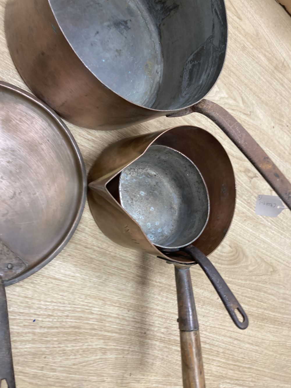 Three 19th century copper pans, one with lid, middle saucepan 27cm diameter